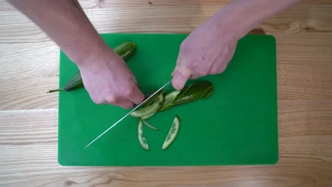 Chef cutting fresh cucumber with a knife 库存影片 147437716