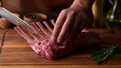 Chef cutting fresh lamb chop on wooden cutting board Stock Footage 270803305