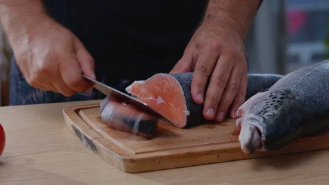 Chef cutting fresh raw salmon (trout) fish into steaks Stock Footage 340507268