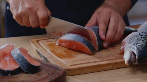 Chef cutting fresh raw salmon (trout) fish into steaks. Stock Footage 345502640