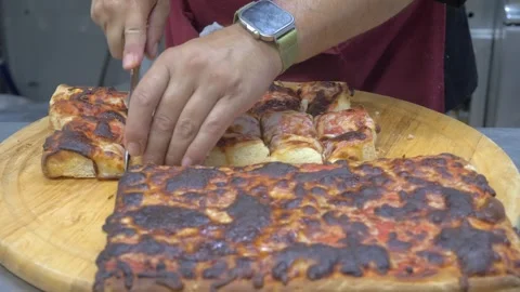 Chef cutting freshly baked thick pizza into small pieces after oven cooking Stockbeeldmateriaal 340153682