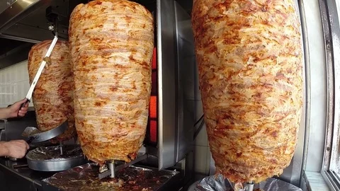 Chef Cutting Grilled Meat Off Rotating Skewer Stock Footage 93899735