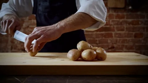 The chef cutting in half boiled potatoes in the kitchen of a restaurant. 4K 库存影片 78422093