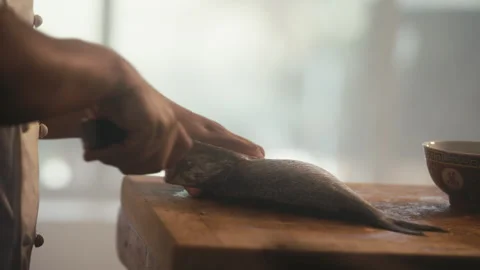 Chef cutting head off fish on cutting board Stock Footage 274618440