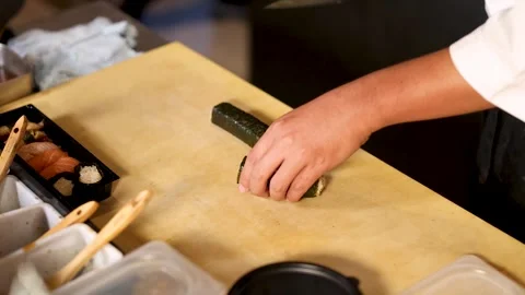 Chef Cutting Maki Sushi Roll on Wooden Board Stock Footage 324844936