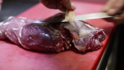 Chef cutting meat in the kitchen on a red board Stock Footage 137945785