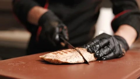 Chef cutting meat with a knife on kitchen table. Stock Footage 202204237