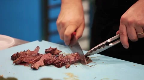 Chef cutting the meat into pieces and put on the plate Stock Footage 61092829