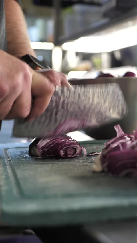 Chef cutting onion on cutting board in restaurant kitchen Stock Footage 306007851