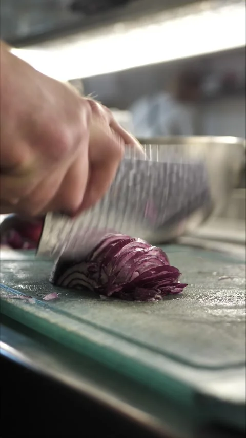 Chef cutting onion on cutting board in restaurant kitchen Stock Footage 306211004