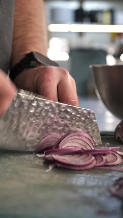 Chef cutting onion on cutting board in restaurant kitchen Stock Footage 306750789