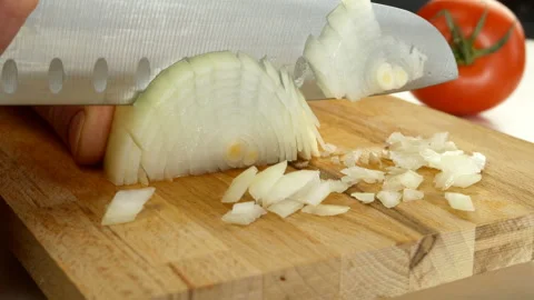 Chef cutting onion with large sharp kitchen knife on wooden chopping board. Stock Footage 146683022