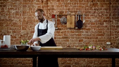 The chef cutting onions on a chopping board for preparing food in a kitchen. 4K Stock Footage 78420682