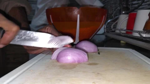 A chef is cutting onions on a cutting board. Stock Footage 294942507