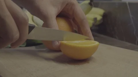 A chef cutting orange on cutting board Stock Footage 92846117