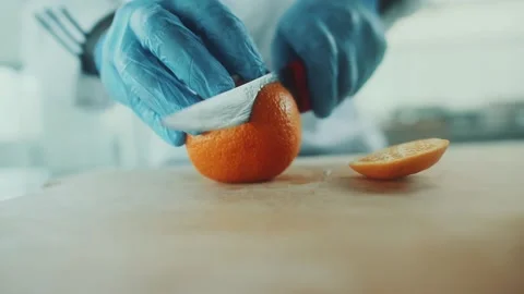 Chef cutting orange with knife Stock Footage 153705564