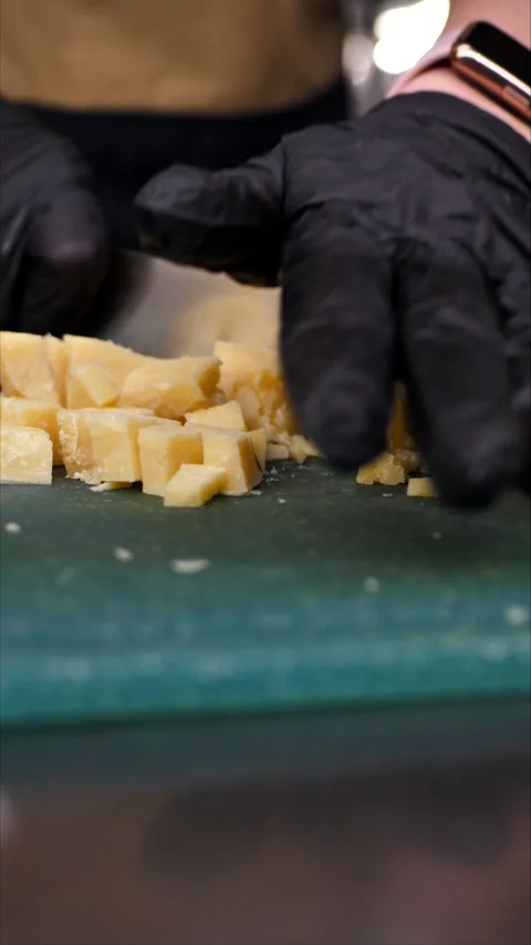 Chef cutting parmesan on a board. A gourmet appetizer or snack. Preparing a Stock Footage 305985078