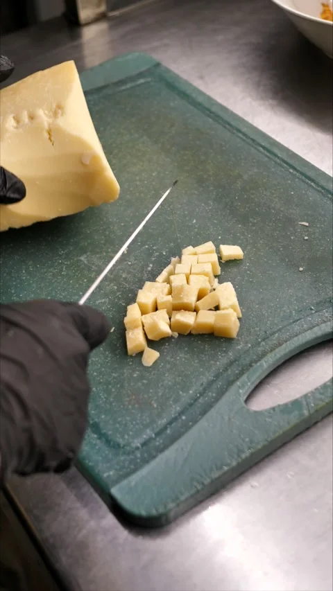 Chef cutting parmesan on a board. A gourmet appetizer or snack. Preparing a Stock Footage 305985121