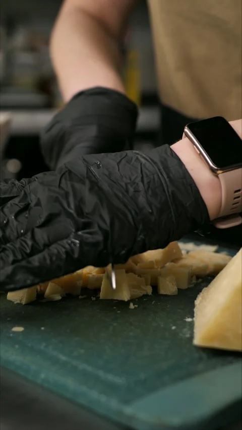 Chef cutting parmesan on a board. A gourmet appetizer or snack. Preparing a Stock Footage 307730140