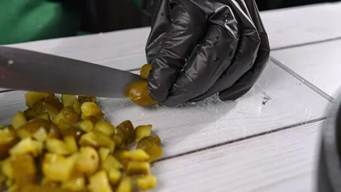 Chef cutting pickled cucumbers on glass cutting board Vidéo 291679797