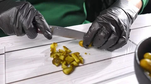 Chef cutting pickled cucumbers on glass cutting board Vidéo 291679915