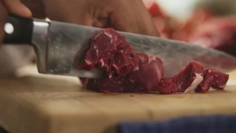Chef cutting a piece of beef to small cubes Stock Footage 274671589