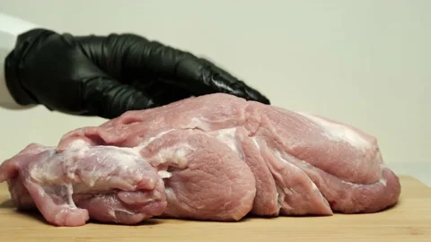 Chef cutting a piece of meat on a kitchen cutting board. Stock Footage 153433092