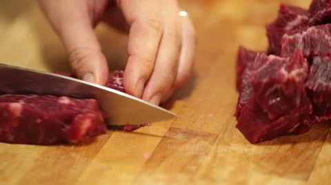 A chef cutting raw beef on a wooden board Stock Footage 68454891