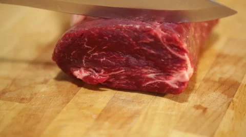 A chef cutting raw beef on a wooden board Stock Footage 68454899