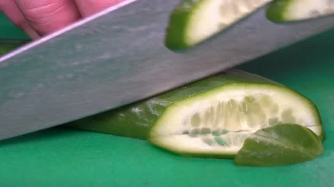 Chef cutting raw cucumber with a knife Vidéo 147437704