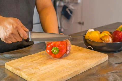 Chef cutting red bell pepper on wooden broad 写真素材