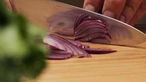 Chef Cutting Red Onions on a Kitchen Board to Add Freshness and Flavor to a Stock Footage 289668159