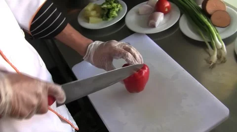 Chef cutting a red pepper, chopped on a table with a knife. Stock Footage 59921389
