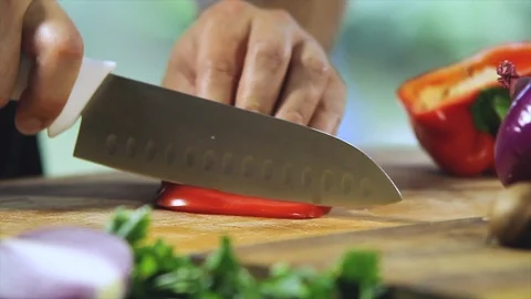 Chef that is cutting a red pepper in a kitchen lit by sunlight Stock Footage 100345719