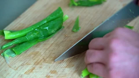 Chef cutting spring onions with the knife on the wooden board Stock Footage 161163124