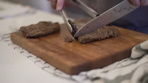 Chef cutting up steak on a cutting board. Video stock 80507865