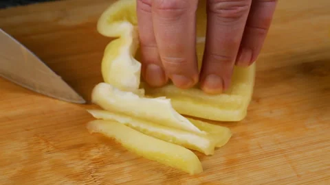 Chef cutting sweet bell pepper into small cubes on a wooden chopping board. 스톡 동영상 341531087