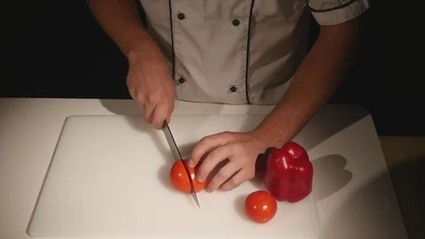 Chef cutting up a tomato with a knife Stock Footage 83986367