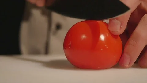 Chef cutting up a tomato with a knife. slow motion. close up Stock Footage 83786004