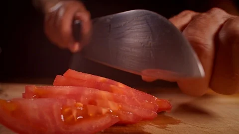 Chef cutting a tomato with a sharp knife, professionally lit studio Stock-Footage 125288428
