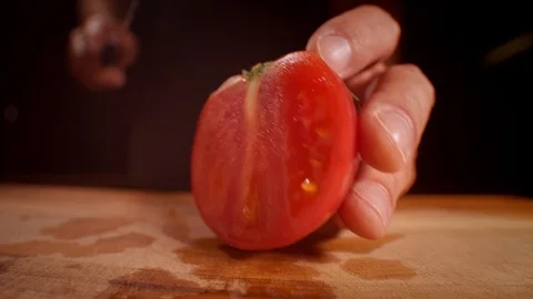 Chef cutting a tomato with a sharp knife, professionally lit studio Stock-Footage 125288451