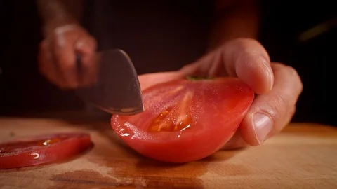 Chef cutting a tomato with a sharp knife, professionally lit studio Stock Footage 125288457