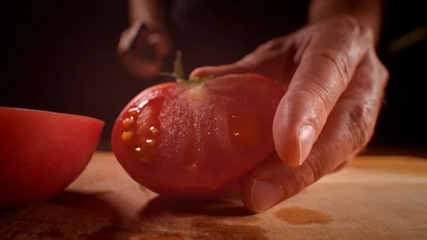 Chef cutting a tomato with a sharp knife, professionally lit studio Stock-Footage 125288477