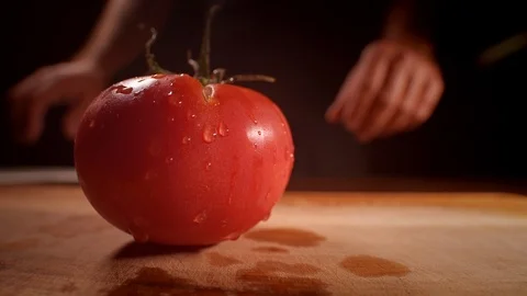 Chef cutting a tomato with a sharp knife, professionally lit studio Stock-Footage 125288478