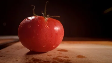 Chef cutting a tomato with a sharp knife, professionally lit studio Stock-Footage 125288508