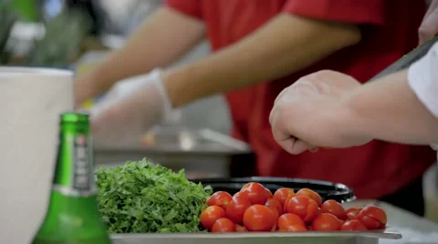 Chef Cutting Tomatoes and Wrapping Bacon in Kitchen Rack Focus Stock Footage 58102554