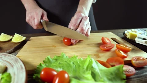 Chef is cutting the tomatoes. Process of preparing a fresh delicious dish Stock Footage 176726262