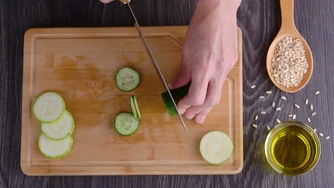 Chef cutting vegetables in kitchen. Slicing cucumber on cutting board Stock Footage 96570412
