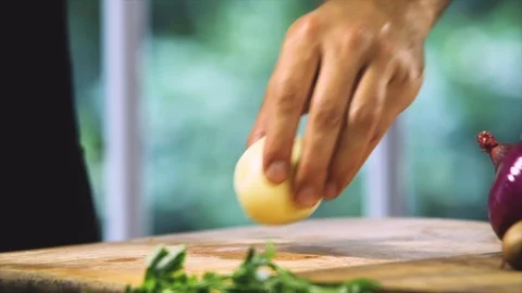Chef cutting a white onion in two parts with a knife Stock Footage 91049108
