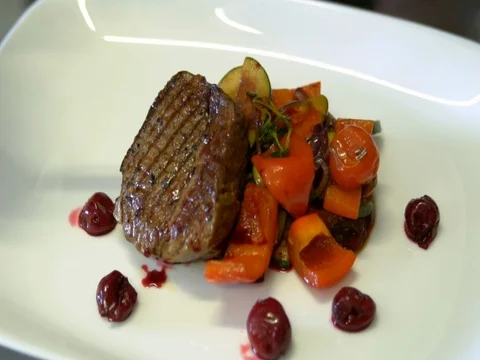 The chef decorated the steak with roasted vegetables. slow motion Video stock 76055919
